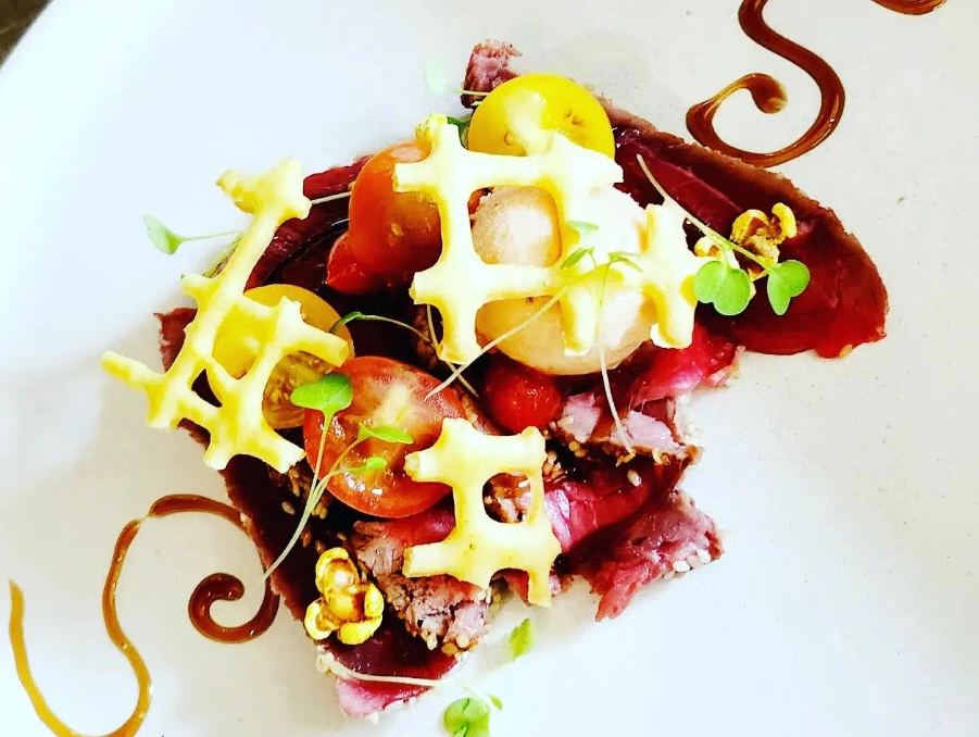 Carpaccio de bœuf dressé, tomates cerises, tuile de fromage et trait de réduction