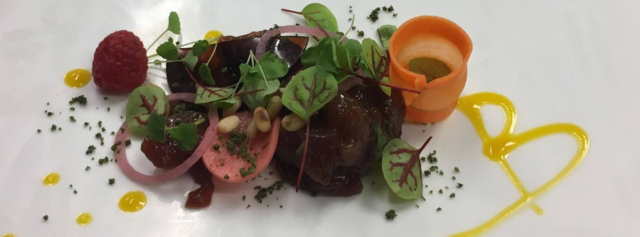 Assiette du chef : viande glacée, pousses de betterave, framboise, rouleau de carotte et trait de sauce jaune
