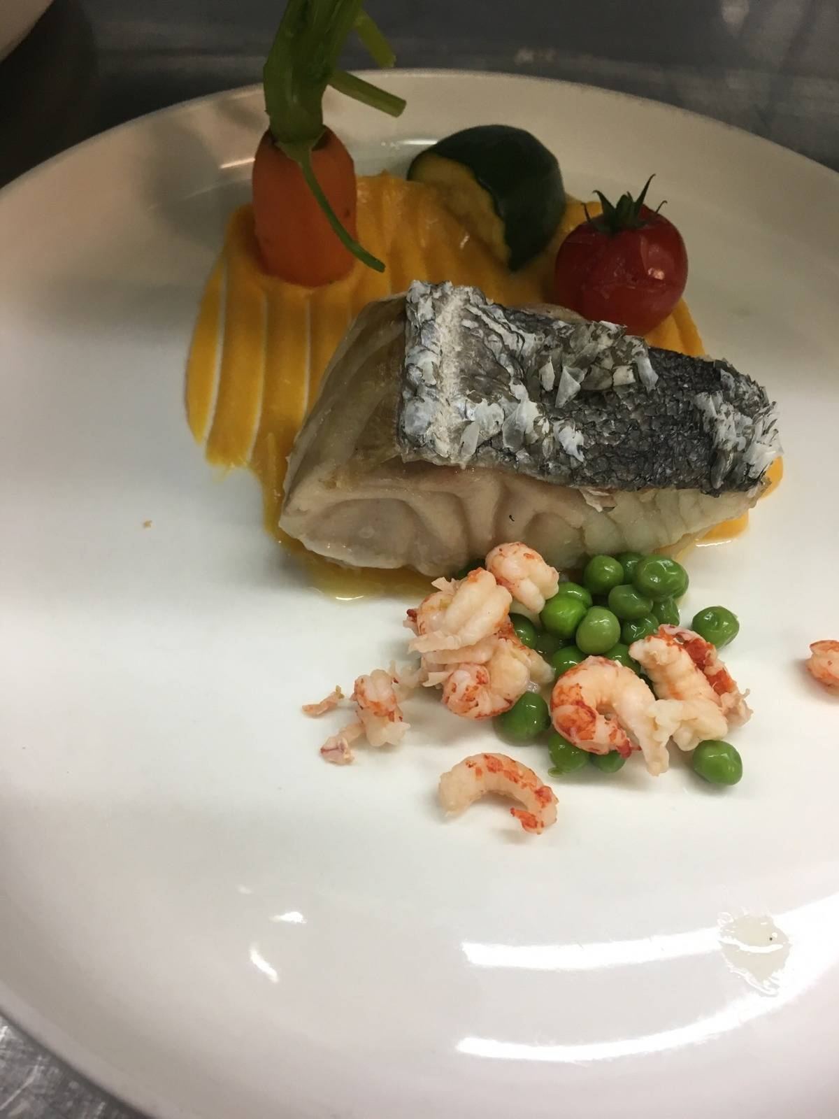 Filet de poisson à la peau grillée, petits pois et crevettes grises