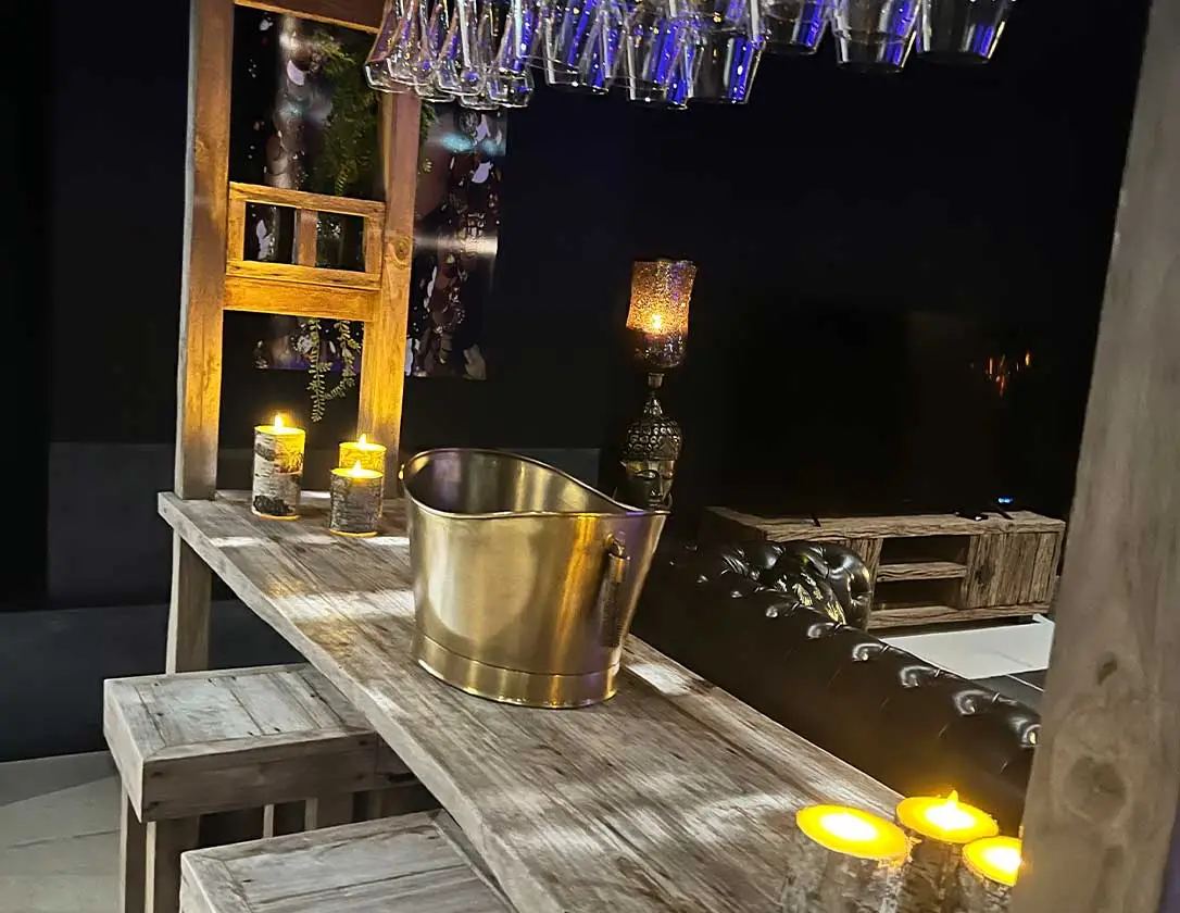 Bar en bois d'une suite, seau à champagne et bougies