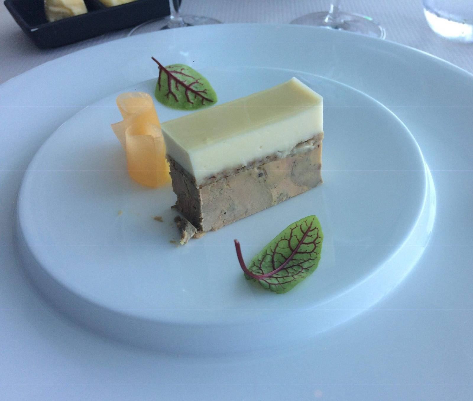 Tranche de foie gras dressée sur une assiette blanche, pousses de betterave